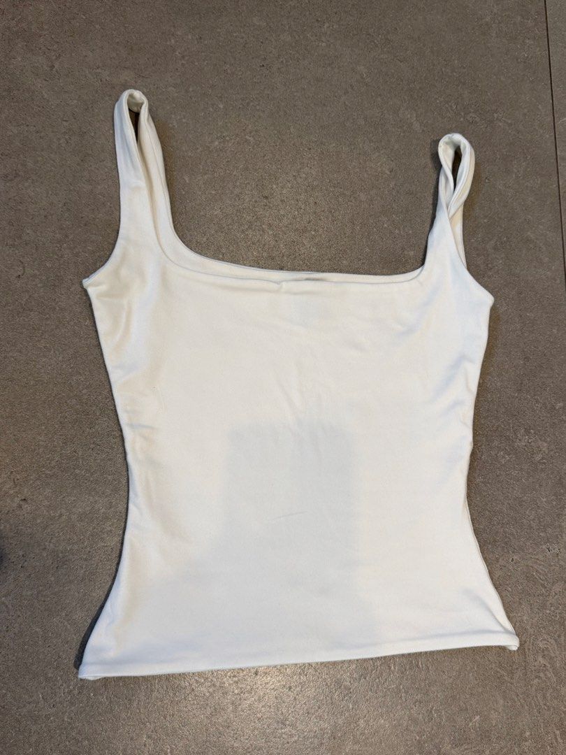 White Square Neck Tank Top (Category: Sleeveless) located in Manila. Submitted by burgerking323 (Listing ID 1463005594, Image 1). Description: - Brand: Mera - Basic white tank top - Square neckline - Thin straps - Fitted style - Versatile: great for layering or wearing on its own - Easy to pair with any wardrobe staple.