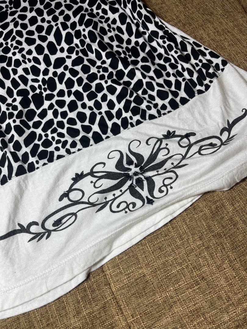 Y2k Embellished Sleeveless (Category: Sleeveless) located in Mexico. Submitted by drei_declutter (Listing ID 1462887476, Image 3). Description: - Krista Lee Sleeveless Top - Size: Medium (M) - Color: White with Black Trim - Design: Bold animal print on back and neckline - Embellishments: Rhinestones and beads on neckline - Front Detail: Dainty dotted lines - Back Hem: Decorative black print.