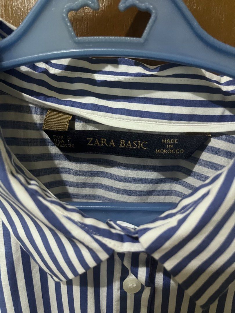 Zara Basic Striped Button-Up Shirt (Category: Longsleeves) located in Pasig City. Submitted by instawardrobe (Listing ID 1463025461, Image 2). Description: - Classic blue stripes - Zara Basic button-up shirt - Long sleeves with buttoned cuffs - Button-down front - Versatile for work or casual outfits - Made in Morocco - Size L.
