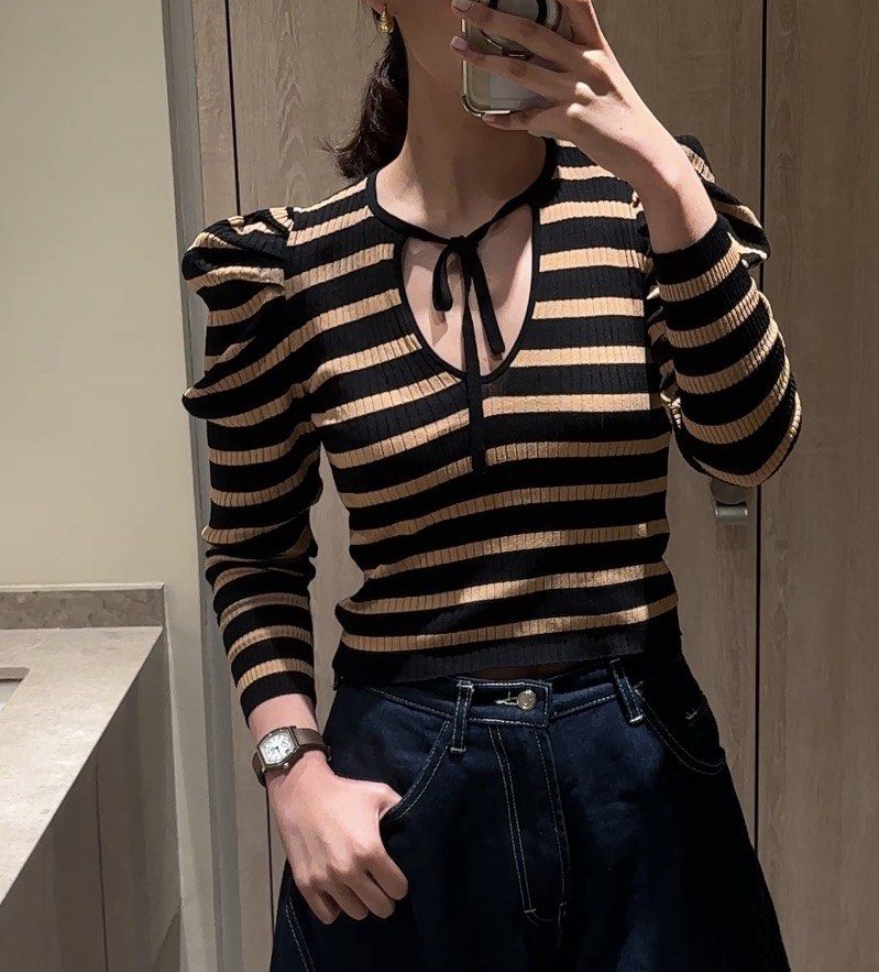 Zara top (Category: Blouses) located in Manila. Submitted by shopelisse (Listing ID 1463025024, Image 1). Description: - Cute black and tan striped top - Features puff sleeves - Adorable tie detail at the neckline - Made from comfortable ribbed knit material - Versatile: pairs well with jeans or skirts - Perfect for casual outings or nights with friends.