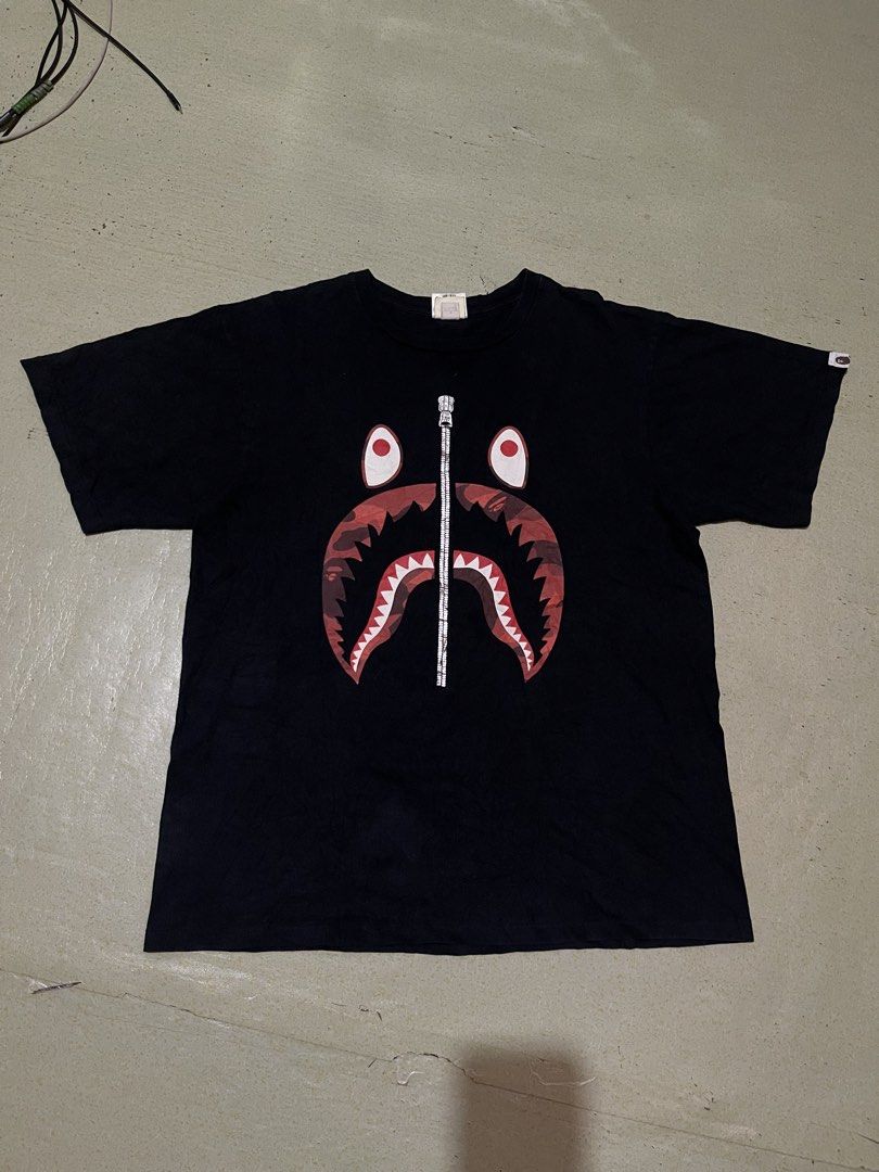 A Bathing Ape BAPE Shark Face Tee XL (Category: Tshirts & Polo Shirts ) located in Manila. Submitted by stuzzygod (Listing ID 1463141412, Image 1). Description: - Classic BAPE Shark Face Graphic Tee - Color: Black with iconic Red Camo Shark - Size: XL on tag but best Fit large - Material: 100% Cotton - Perfect addition to any streetwear collection - Dimes 22*28 - No issue.