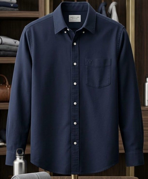 American Eagle Long Sleeve Button-Down Shirt (Navy Blue) (Category: Tshirts & Polo Shirts ) located in San Juan City. Submitted by kera.g815 (Listing ID 1463163463, Image 1). Description: Classic American Eagle long sleeve button-down shirt in solid navy blue. Crafted from soft, breathable cotton with a comfortable, relaxed fit. Features a single chest pocket with subtle tonal eagle logo embroidery and contrasting white buttons. Product Details B