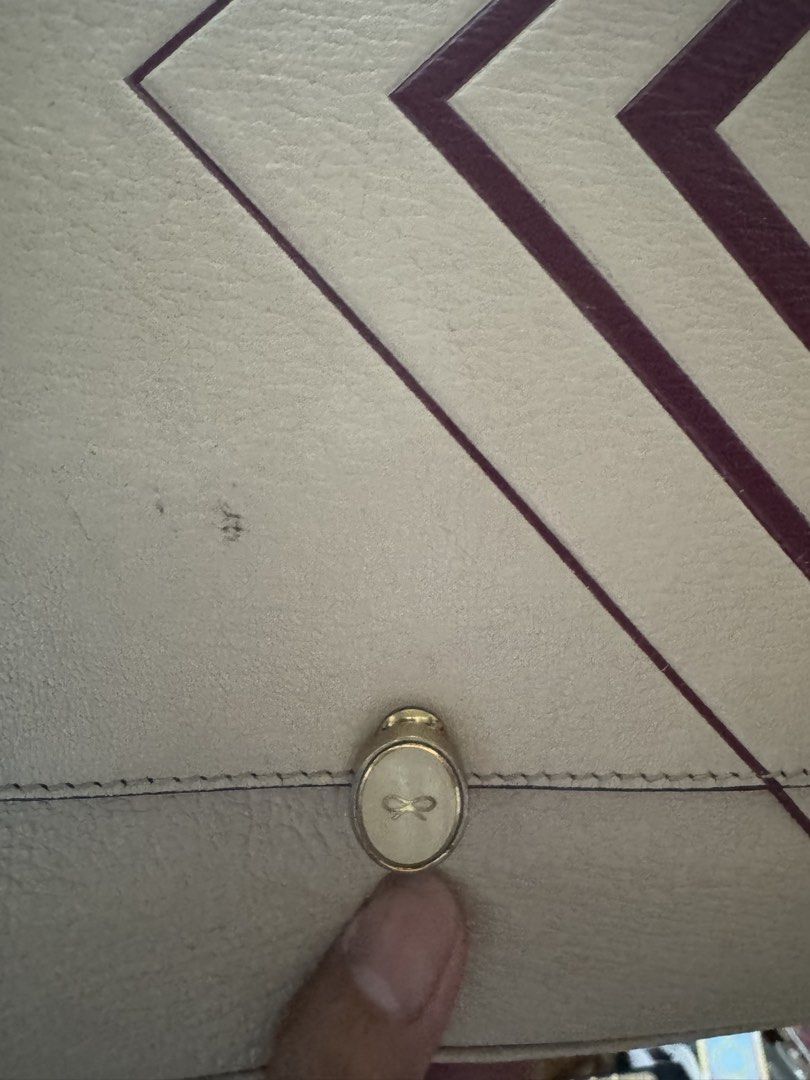 ANYA HINDMARCH (Category: Shoulder Bags) located in Quezon City. Submitted by angel12171984 (Listing ID 1463286050, Image 2). Description: Brand : ANYA HINDMARCH handbag crafted from textured chalk-white leather with a distinct geometric red chevron design on the side and a patterned handle Rank : 7/10 With some dirt on front AUTHENTIC Missing Sling.