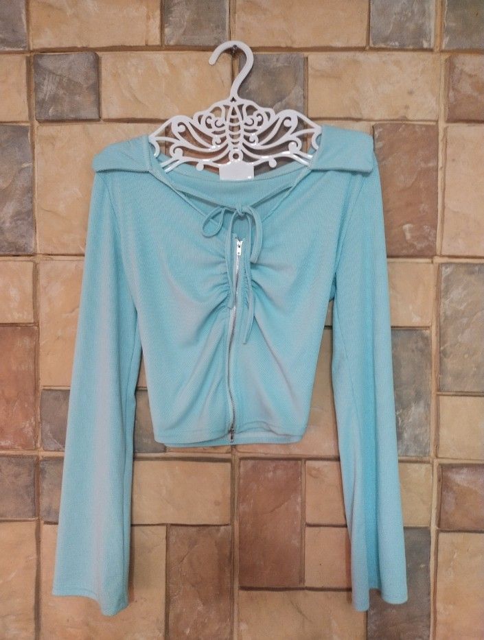 Aqua Blue Ribbed Ruched Zip Up Crop Top (Category: Others Tops) located in Manila. Submitted by misrezuri (Listing ID 1463147944, Image 1). Description: - Aqua blue ribbed crop top - Ruched front with zip closure and tie detail - Long bell sleeves - Super cute and trendy - Perfect for layering or wearing solo.