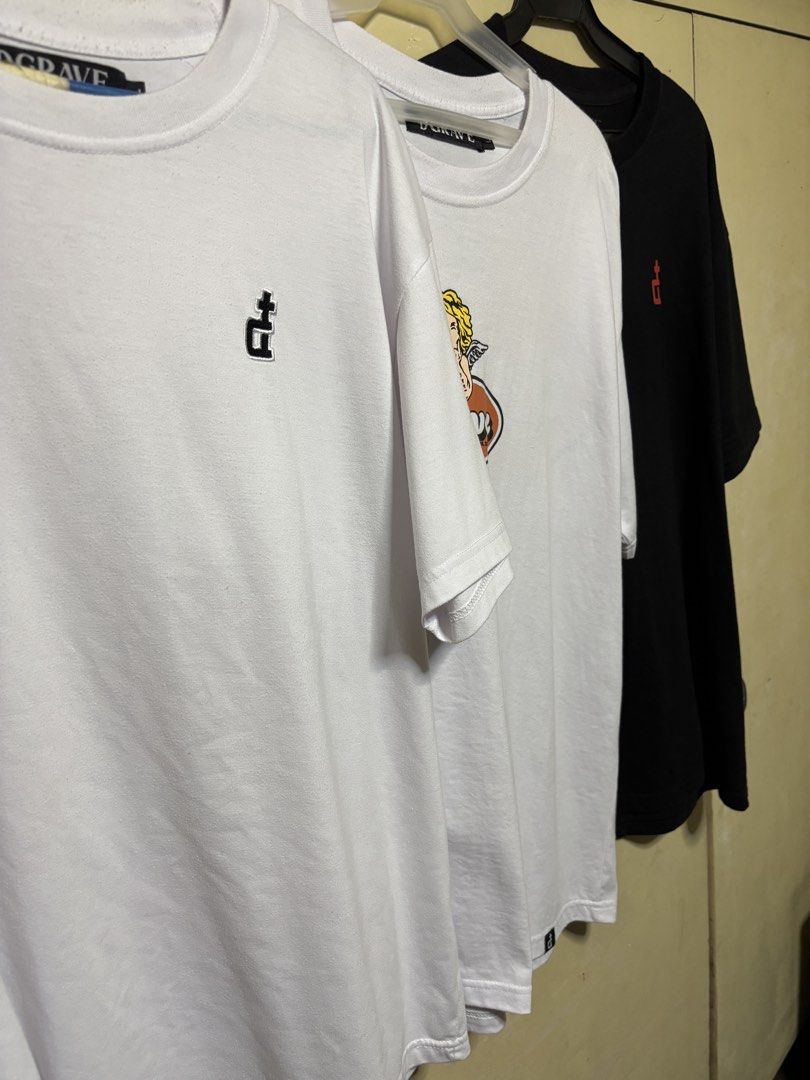 Assorted DGrave Graphic T-shirts - White & Black (Category: Tshirts & Polo Shirts ) located in Quezon City. Submitted by denmarkkno44009 (Listing ID 1463222931, Image 1). Description: - All Large (W 23) (L 29) - Set of 3 graphic t-shirts - Two white tees with unique embroidered logos - One black tee with a red embroidered logo - Classic short-sleeved, crew neck style - Versatile basics for any outfit - Available for individual purchase or as a bu