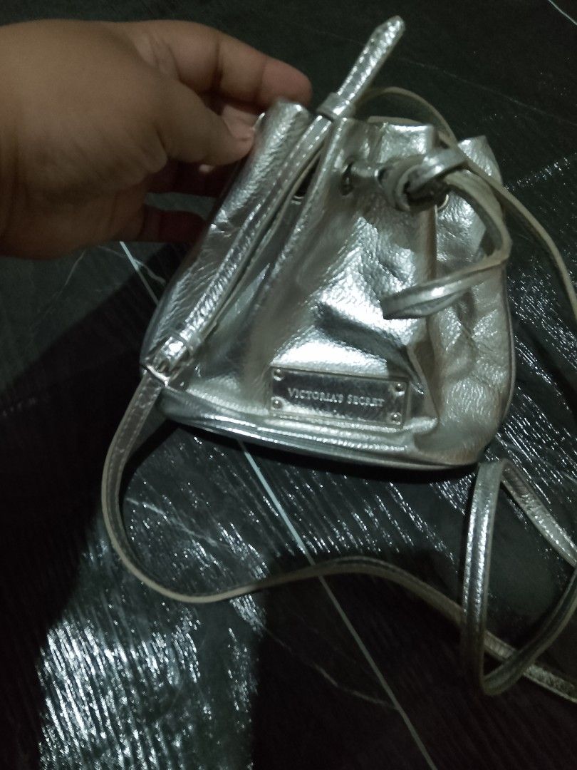 AUTHENTIC VICTORIA'S SECRET SILVER METALLIC MINI DRAWSTRING BUCKET BAG ✨💖 (Category: Cross-body Bags) located in Manila. Submitted by annbernabe28 (Listing ID 1463290971, Image 3). Description: ✨ AUTHENTIC Victoria's Secret Silver Metallic Mini Drawstring Bucket Bag ✨💰 PRICE: ₱800 (Slightly negotiable for serious buyers!)🪐 AESTHETIC: Perfect for Cyber Y2K, McBling, Space-Age, and 2000s fashion trends. Very trendy liquid-silver foil look!👜 DET
