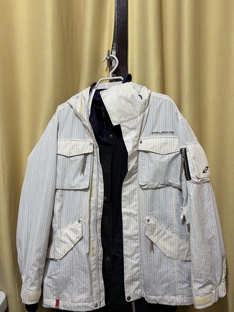 Avalanche Pinstripe Hooded Jacket (Category: Coats, Jackets and Outerwear) located in Baguio. Submitted by fionabanana (Listing ID 1463254459, Image 1). Description: - White jacket with subtle pinstripe pattern - Attached hood for extra protection - Multiple functional pockets on front and sleeves - Zipper closure on front and sleeves - Visible inner dark colored layer - Ideal for outdoor activities and adventures.