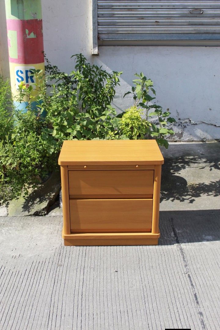 Bedside Table (Category: Tables & Sets) located in Meycauayan. Submitted by marygracecasimiro (Listing ID 1463260437, Image 2). Description: Modern Wooden Bedside Table with Pull-Out Tray Two spacious drawers, a convenient pull-out tray, rounded edges and a sturdy plinth base. Finished in a light honey-oak tone, perfect for bedrooms, living rooms or compact spaces L:23 ¾ • W:15 ¾ • H:22 ¼ inches 5,000 pesos only🩷🧡.
