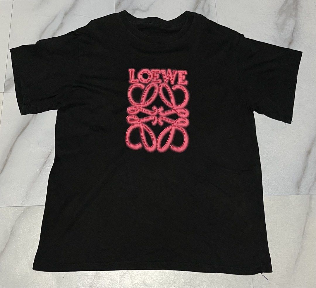 Black Loewe Anagram T-Shirt (Category: Shirts) located in Cavite. Submitted by christianzuuu (Listing ID 1463133922, Image 1). Description: - Black crew neck t-shirt - Features a fuzzy, neon-like pink Loewe anagram logo - Short sleeves - Ideal for casual wear - Comfortable and stylish.