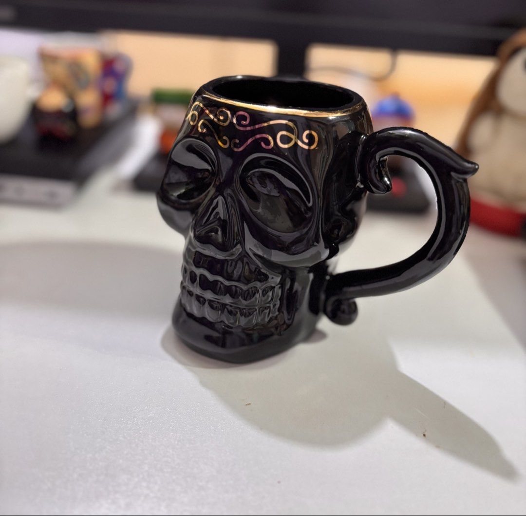 Black Skull Mug with Gold Swirls (Category: Coffee & Tea Tableware) located in Bacoor. Submitted by dangeusebio1515 (Listing ID 1460907757, Image 3). Description: - Unique black skull design - Elegant gold swirls on the rim - Ideal for coffee, tea, or any drink - Perfect gift for gothic or spooky decor lovers - Dishwasher and microwave safe - Comfortable handle for easy grip.