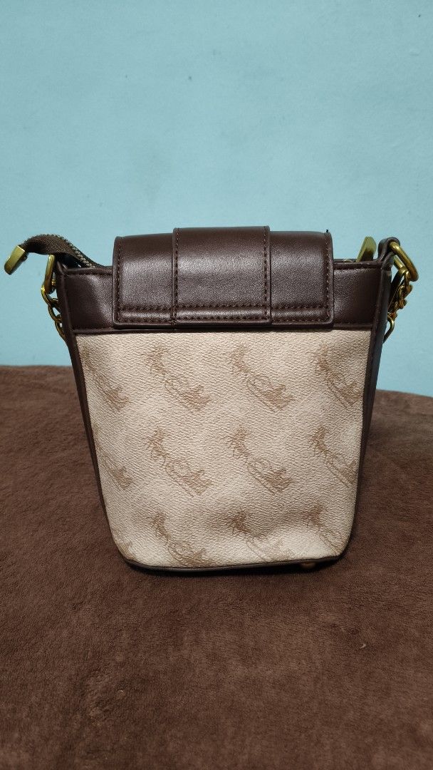 Brown and beige patterned bucket bag with gold chain strap (Category: Cross-body Bags) located in Manila. Submitted by serenitycarlylle (Listing ID 1463302127, Image 2). Description: - Adorable bucket bag with a stylish patterned body. - Chic brown trim and secure flap closure. - Elegant gold chain strap for comfortable carrying. - Includes a convenient zippered compartment inside. - Ideal for everyday use, fitting all your essentials..