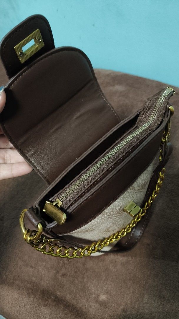 Brown and beige patterned bucket bag with gold chain strap (Category: Cross-body Bags) located in Manila. Submitted by serenitycarlylle (Listing ID 1463302127, Image 3). Description: - Adorable bucket bag with a stylish patterned body. - Chic brown trim and secure flap closure. - Elegant gold chain strap for comfortable carrying. - Includes a convenient zippered compartment inside. - Ideal for everyday use, fitting all your essentials..