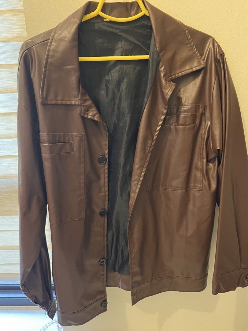 Brown Faux Leather Button-Up Jacket (Category: Coats, Jackets and Outerwear) located in Las Pinas. Submitted by basicapparel_mnl (Listing ID 1463198934, Image 3). Description: - Cool brown jacket - Faux leather look - Two chest pockets - Button front closure - Black lining - Ideal for layering - Versatile for casual or dressed-up styles.
