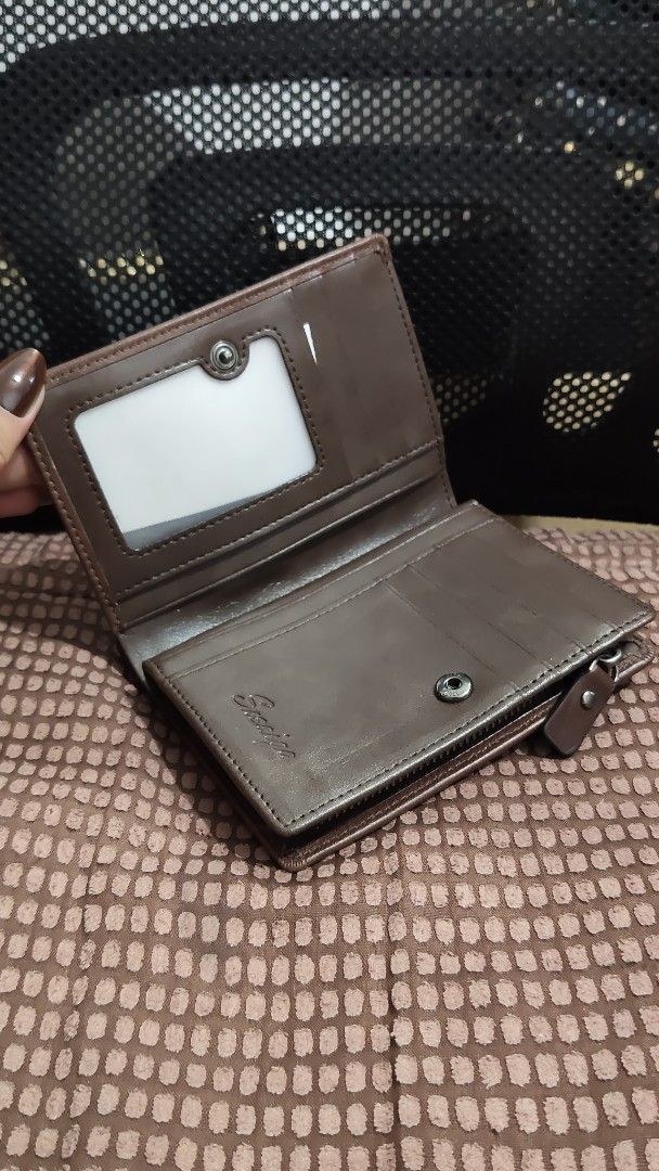 Brown Leather Bi-fold Wallet with Coin Compartment (Category: Wallets & Card holders) located in Taguig. Submitted by ceefam.online.shop (Listing ID 1463147463, Image 1). Description: - Genuine brown leather wallet - Clear ID window for easy access - Multiple card slots to organize your essentials - Secure zippered coin pocket - Subtle embossed brand name on front and inside - Classic, functional design.