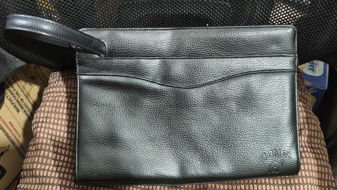 Camel Leather Clutch Bag with Wrist Strap (Category: Clutches) located in Taguig. Submitted by ceefam.online.shop (Listing ID 1463148032, Image 1). Description: - Genuine black leather clutch from Camel - Convenient wrist strap for easy carrying - Stylish curved pocket on the front - Subtle embossed Camel logo on the bottom right - Ideal for organizing your daily essentials.