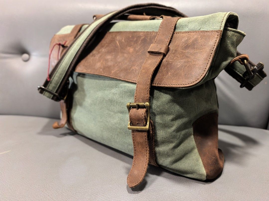 Canvas and Leather Messenger Bag (not filson) (Category: Luxury Bags & Wallets) located in Cagayan de Oro. Submitted by pootx (Listing ID 1463268906, Image 1). Description: - Durable green canvas messenger bag - Stylish brown leather accents - Main compartment with interior zippered pocket - Front flap with additional zippered pocket - Adjustable shoulder strap for comfort - Dimensions: Approximately 14 inches wide x 10 inches tall.