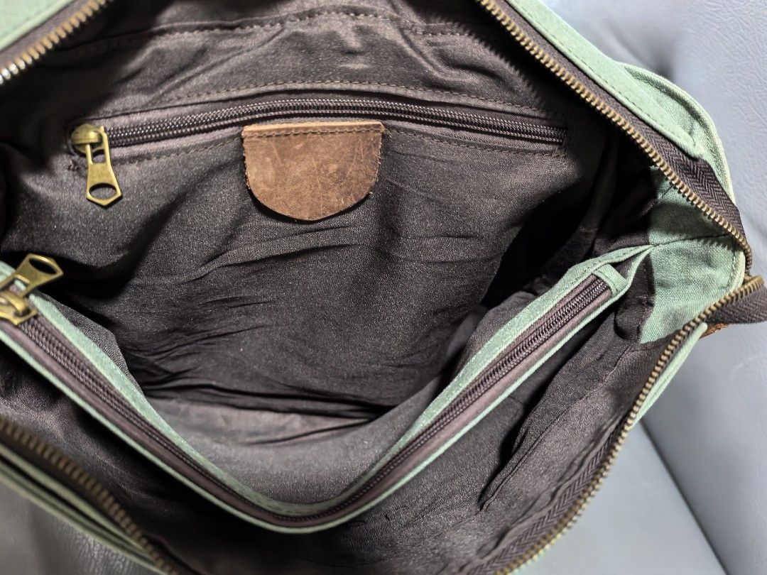 Canvas and Leather Messenger Bag (not filson) (Category: Luxury Bags & Wallets) located in Cagayan de Oro. Submitted by pootx (Listing ID 1463268906, Image 3). Description: - Durable green canvas messenger bag - Stylish brown leather accents - Main compartment with interior zippered pocket - Front flap with additional zippered pocket - Adjustable shoulder strap for comfort - Dimensions: Approximately 14 inches wide x 10 inches tall.