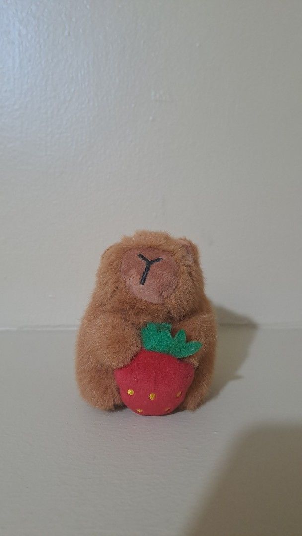 Capybara keychain holding a strawberry (Category: Character Goods) located in Muntinlupa City. Submitted by repurp0se (Listing ID 1463275610, Image 2). Description: Pls adopt this capybara keychain!!! - Great condition - Might be a bit dusty but thats all Rfs: Need funds for school .