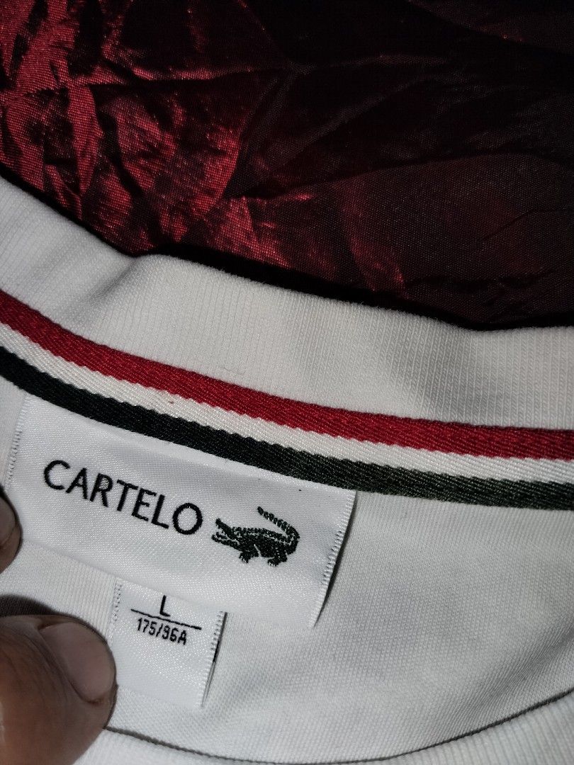 Cartelo Tennis Tee (Category: Tshirts & Polo Shirts ) located in Mabalacat. Submitted by al_amin_thrift (Listing ID 1463227836, Image 3). Description: - Brand: Cartelo — established 1947, premium casual wear ​ - Size: Large (175/96A) — regular comfortable fit ​ - Material: 100% Cotton — soft, breathable, cool on skin ​ - Design Details: ✅ Embroidered crocodile logo on left chest ✅ Red-green-white striped crew neck trim ✅ Tennis-themed patch on sl