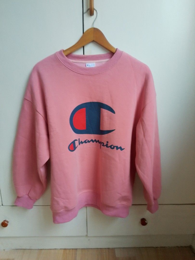 Champion Pink Crewneck Sweatshirt Medium (Category: Coats, Jackets and Outerwear) located in Bogo. Submitted by algarme2018 (Listing ID 1463149847, Image 1). Description: - Pink Champion sweatshirt - Features classic Champion logo on front - Tag size: Medium - Made in China - Perfect for casual wear - Comfortable and stylish.
