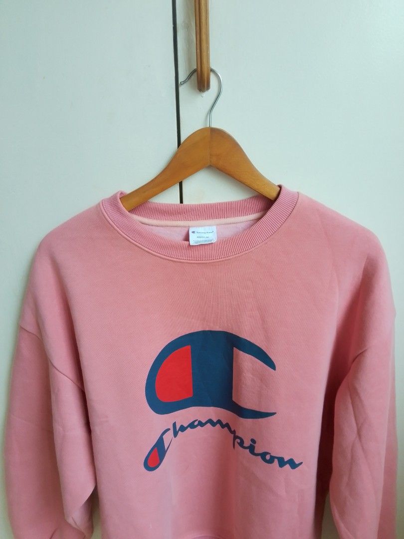 Champion Pink Crewneck Sweatshirt Medium (Category: Coats, Jackets and Outerwear) located in Bogo. Submitted by algarme2018 (Listing ID 1463149847, Image 2). Description: - Pink Champion sweatshirt - Features classic Champion logo on front - Tag size: Medium - Made in China - Perfect for casual wear - Comfortable and stylish.