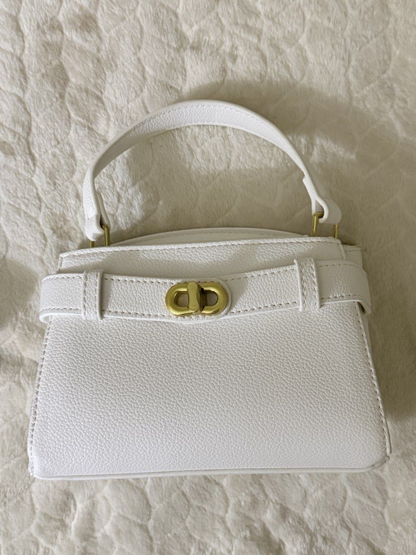 Charles & Keith White Top Handle Bag (Category: Shoulder Bags) located in Quezon City. Submitted by unforgettwble. (Listing ID 1463302726, Image 1). Description: - Cute white textured handbag - Gold clasp closure on front flap - Matching textured top handle - Small and compact size - Ideal for carrying essentials.