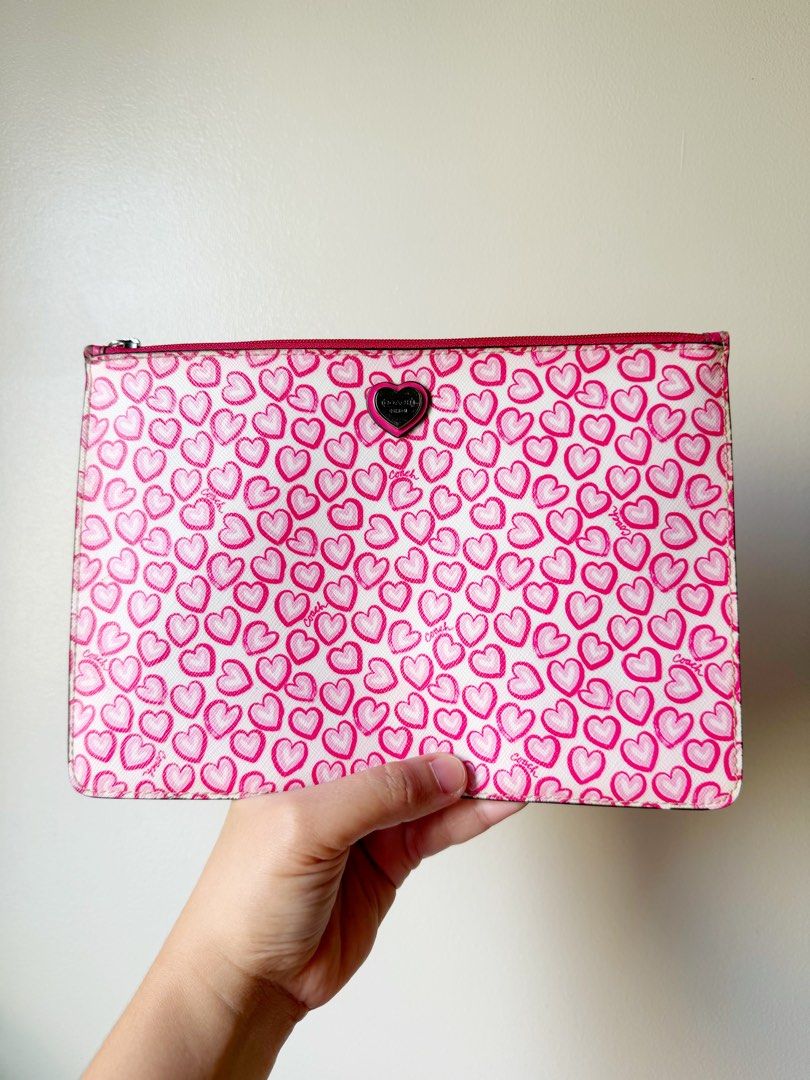 Coach Heart Print Pouch (Category: Purses & Pouches) located in Taguig. Submitted by wuuuby (Listing ID 1463307449, Image 1). Description: - Adorable Coach pouch with a playful all-over pink heart print. - Crisp white background adorned with bright pink hearts. - Secure zipper closure with a matching pink pull tab. - Eye-catching vibrant pink interior. - Ideal for keeping your essentials organized or as a stylish standalone clutch..