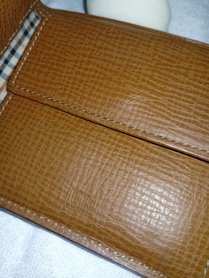 Daks London Brown Leather Bifold Wallet (Category: Wallets & Card holders) located in Davao. Submitted by lingxu23 (Listing ID 1463145496, Image 3). Description: - Brand: Daks London - Material: Brown Leather - Design: Bifold wallet - Interior: Classic check lining - Features: Coin pouch with snap closure, multiple card slots and compartments - Condition: Shows some signs of wear, but still in good shape - Ideal for: Everyday use.
