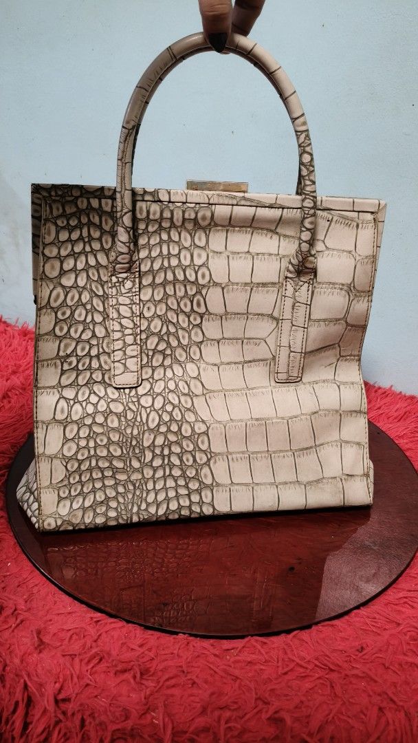 Daphne Designer Crocodile Embossed Handbag (Category: Luxury Bags & Wallets) located in Manila. Submitted by serenitycarlylle (Listing ID 1463303307, Image 2). Description: - White crocodile embossed handbag - Structured shape - Top handles - Interior zippered pocket - Clasp closure - Versatile for everyday or special occasions - A timeless classic With normal signs of use.