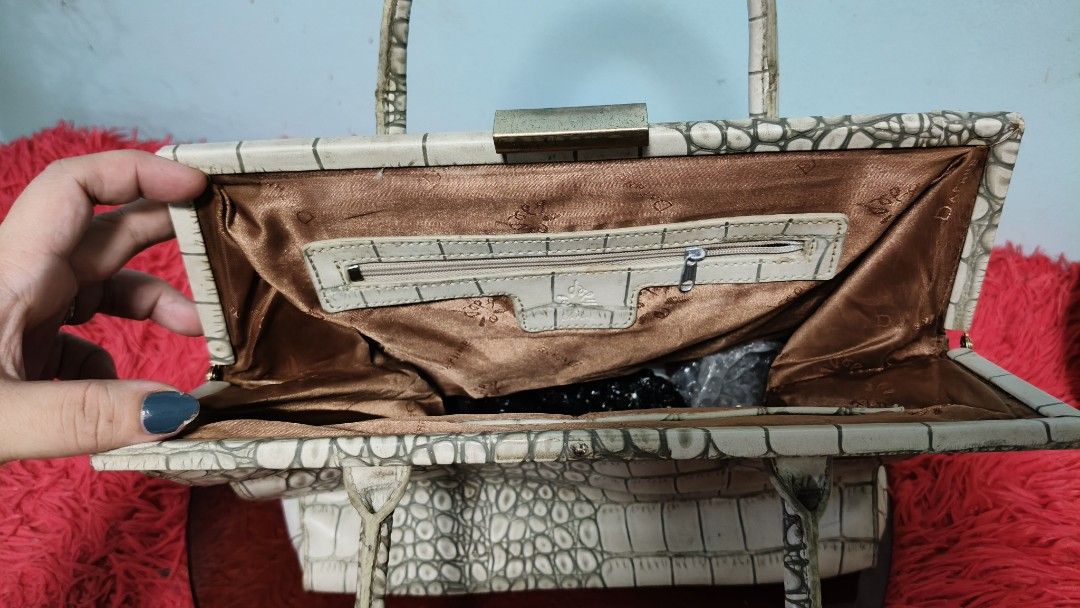 Daphne Designer Crocodile Embossed Handbag (Category: Luxury Bags & Wallets) located in Manila. Submitted by serenitycarlylle (Listing ID 1463303307, Image 3). Description: - White crocodile embossed handbag - Structured shape - Top handles - Interior zippered pocket - Clasp closure - Versatile for everyday or special occasions - A timeless classic With normal signs of use.