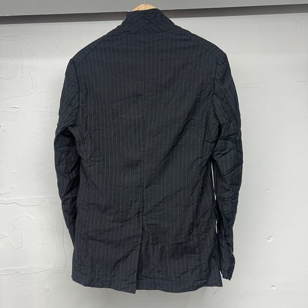 Dark Pinstripe Blazer Jacket (Category: Luxury Apparel) located in Manila. Submitted by icamalicdem29 (Listing ID 1463269954, Image 3). Description: - Dark blazer with a classic pinstripe pattern. - Features a two-button front closure. - Two flap pockets on the lower front for practicality. - Button details on the cuffs add a refined touch. - Please note: a small snag is visible on the fabric near the lapel. - Ideal for creating stylish smart cas