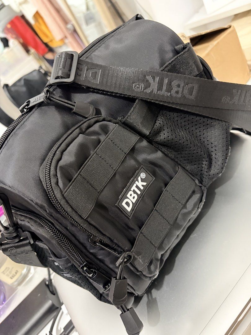 DBTK Black Crossbody Bag (Category: Sling Bags) located in Marikina City. Submitted by renshin17 (Listing ID 1463141047, Image 1). Description: - Black DBTK crossbody bag - Multiple zippered compartments for organized storage - Molle webbing for customizable attachments - Adjustable strap with prominent DBTK branding - Durable material built to last - Ideal for everyday carry or travel needs Bnew Natanggal ko lang tags pero di pa nagamit.