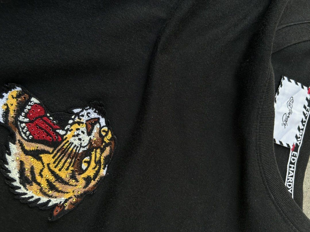 Ed Hardy Black T-Shirt with Tiger Patch (Category: Tshirts & Polo Shirts ) located in Angeles City. Submitted by luxy.thrifts (Listing ID 1463243197, Image 3). Description: - Black Ed Hardy T-shirt - Size L (based on tag) - Classic Ed Hardy script logo on the back - Cool tiger patch on the front left chest - Ed Hardy branding tape on the collar -Angeles City, Pampanga 📍 .