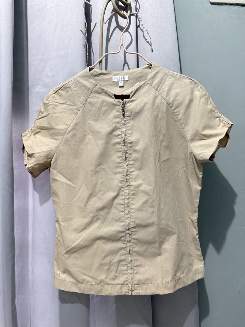 ELLE Short Sleeve Zip Up Top Beige (Category: Blouses) located in Cagayan de Oro. Submitted by ninaaam (Listing ID 1463271731, Image 2). Description: - Beige short sleeve top from ELLE - Full zip-up front - Round neckline - Short sleeves with a slight ruffle detail - Lightweight material - Ideal for casual wear or layering.