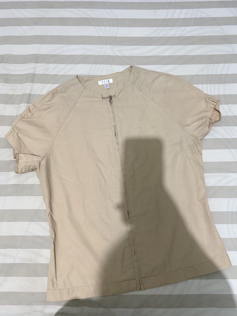 ELLE Short Sleeve Zip Up Top Beige (Category: Blouses) located in Cagayan de Oro. Submitted by ninaaam (Listing ID 1463271731, Image 1). Description: - Beige short sleeve top from ELLE - Full zip-up front - Round neckline - Short sleeves with a slight ruffle detail - Lightweight material - Ideal for casual wear or layering.