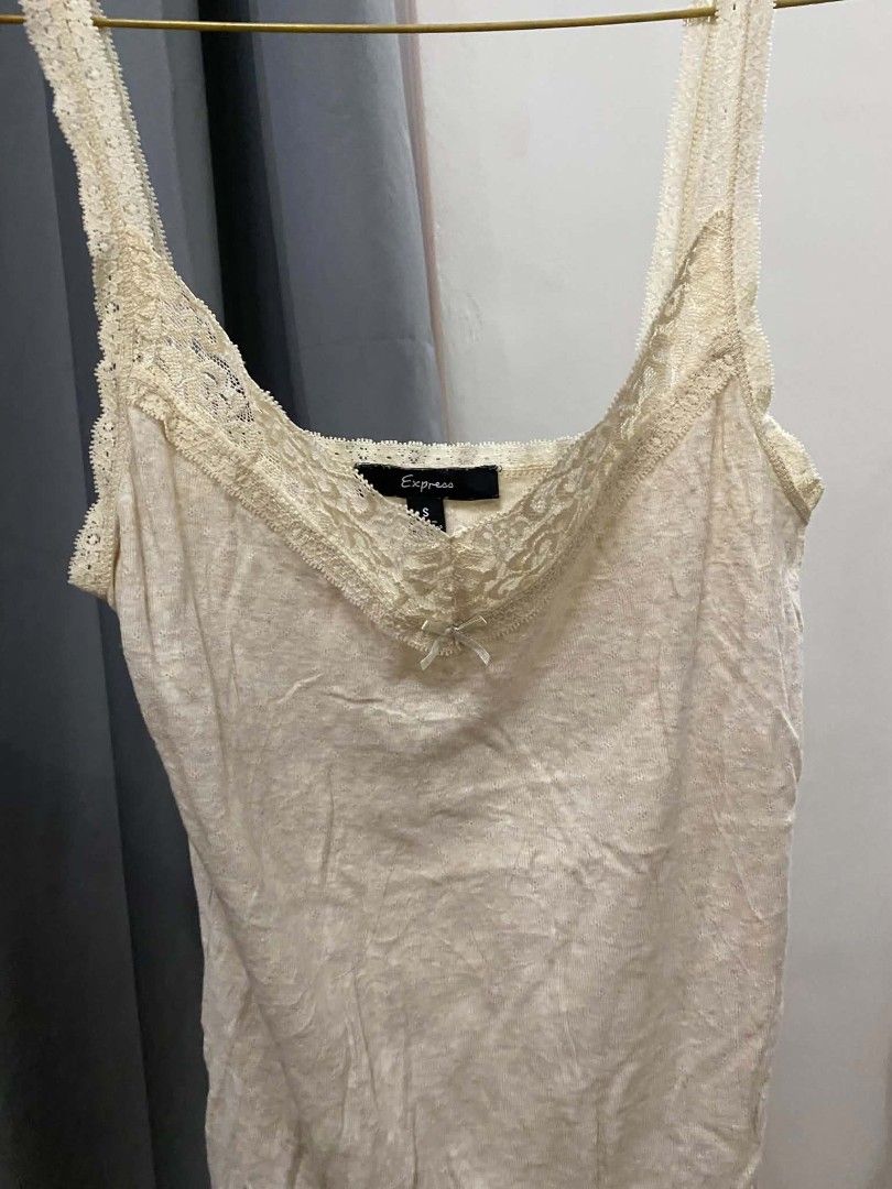 Express Lace Trim Cami Top Cream (Category: Sleeveless) located in Malasiqui. Submitted by finnley26 (Listing ID 1463168488, Image 1). Description: - Cream colored cami top from Express - Features delicate lace trim along the neckline and straps - Adorable small bow detail in the front - Made with soft, comfortable fabric - Versatile piece: great for layering or wearing on its own.