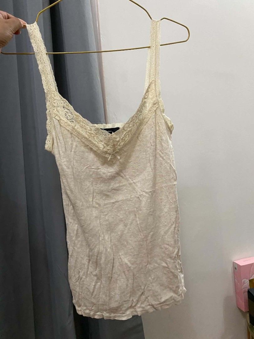 Express Lace Trim Cami Top Cream (Category: Sleeveless) located in Malasiqui. Submitted by finnley26 (Listing ID 1463168488, Image 3). Description: - Cream colored cami top from Express - Features delicate lace trim along the neckline and straps - Adorable small bow detail in the front - Made with soft, comfortable fabric - Versatile piece: great for layering or wearing on its own.
