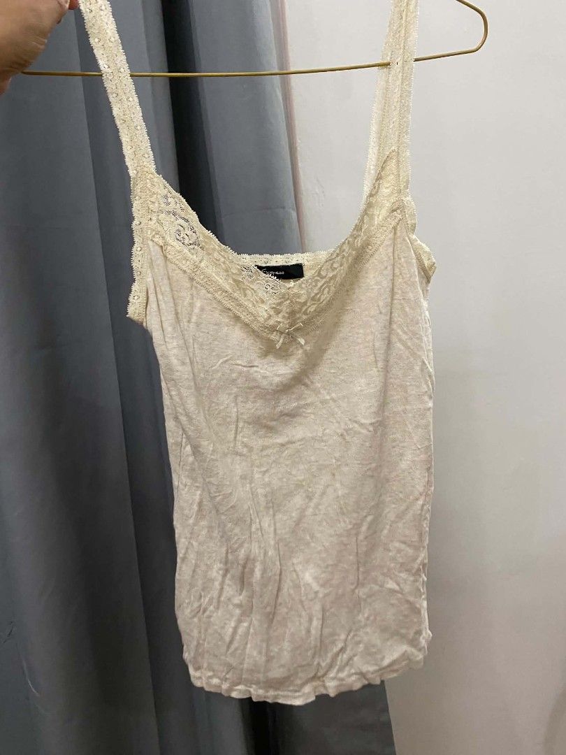 Express Lace Trim Cami Top Cream (Category: Sleeveless) located in Malasiqui. Submitted by finnley26 (Listing ID 1463168488, Image 2). Description: - Cream colored cami top from Express - Features delicate lace trim along the neckline and straps - Adorable small bow detail in the front - Made with soft, comfortable fabric - Versatile piece: great for layering or wearing on its own.