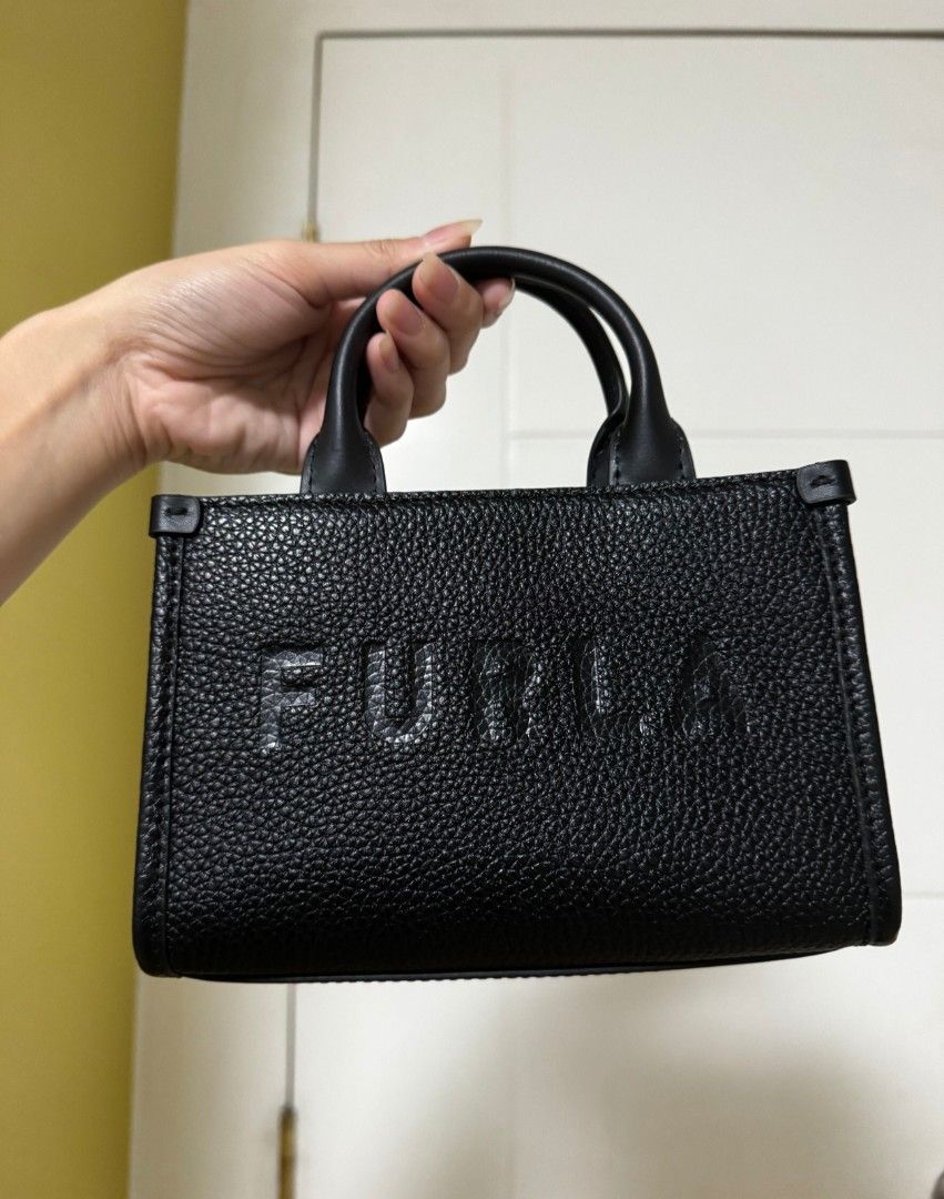 Furla Black Mini Tote Bag with Strap (Category: Luxury Bags & Wallets) located in Cavite. Submitted by nicnic20 (Listing ID 1463163422, Image 2). Description: - Authentic Black Furla Mini Tote Bag - Made of premium textured leather - Features elegant top handles - Includes a detachable shoulder strap for versatile wear - Comes with original dust bag, shopping bag, and tags - Compact and ideal for carrying your daily essentials - Chic and practica