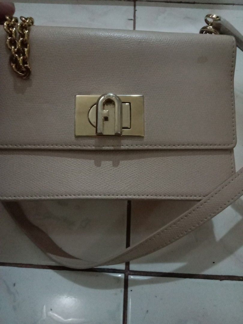 Furla Genuine Leather Chain Shoulder Bag (Category: Luxury Bags & Wallets) located in Rosario. Submitted by gmarilyn1934608 (Listing ID 1463139912, Image 2). Description: - Genuine Furla leather shoulder bag - Color: Light beige - Strap: Gold chain - Closure: Turn-lock - Interior: Shows some light marks and a bit of color transfer - Exterior: Looks good - Style: Classic and timeless piece.
