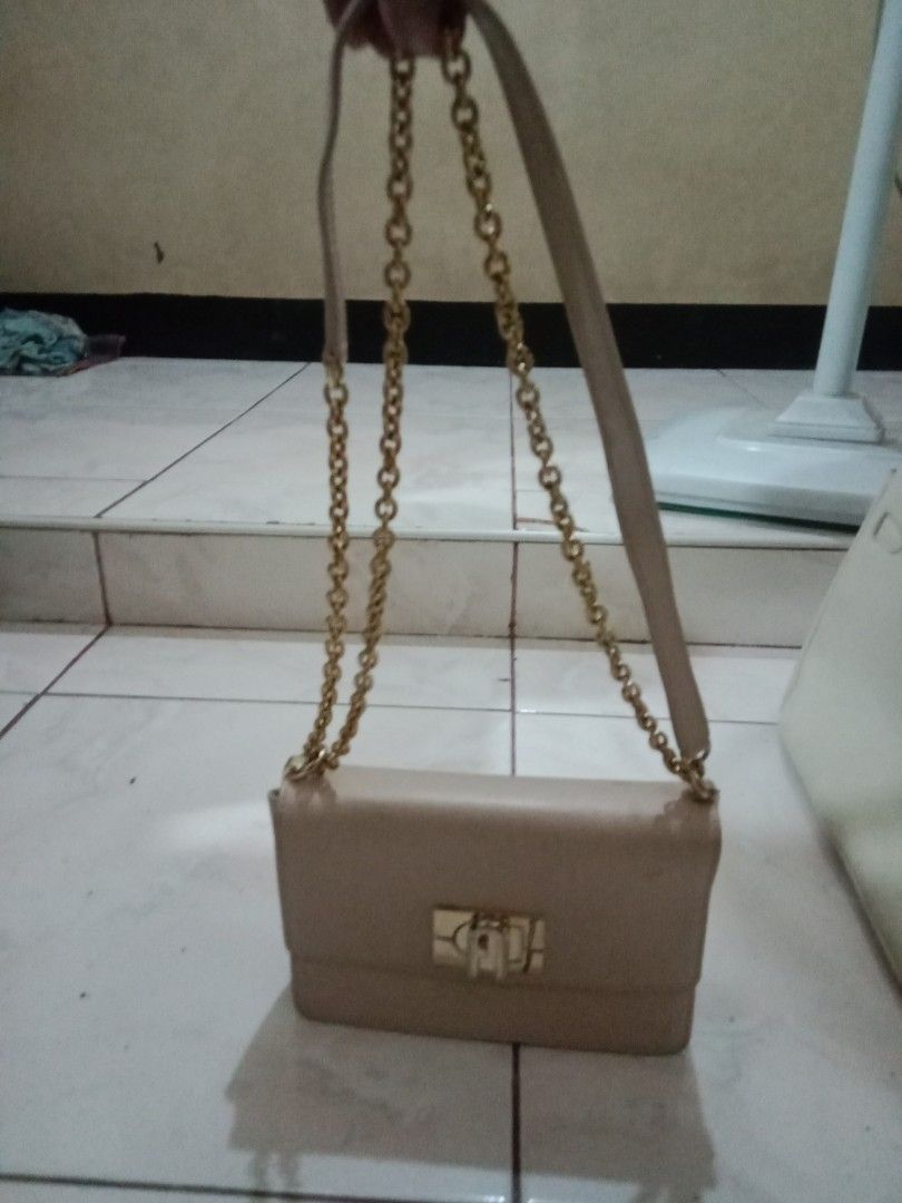 Furla Genuine Leather Chain Shoulder Bag (Category: Luxury Bags & Wallets) located in Rosario. Submitted by gmarilyn1934608 (Listing ID 1463139912, Image 1). Description: - Genuine Furla leather shoulder bag - Color: Light beige - Strap: Gold chain - Closure: Turn-lock - Interior: Shows some light marks and a bit of color transfer - Exterior: Looks good - Style: Classic and timeless piece.