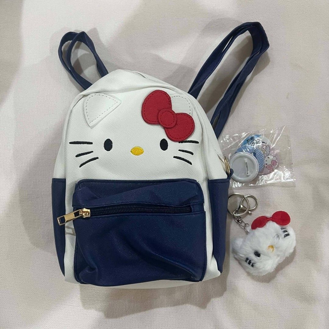 Hello Kitty & Friends Mini Backpacks Set (Category: Stationery & School Supplies) located in Mangaldan. Submitted by ice_thrift_hub (Listing ID 1463312355, Image 1). Description: - Two adorable Kitty themed backpacks. - White and navy mini backpack with front zip pocket. - Mini backpack includes a small Kitty keychain and button pin. - Larger, sparkly blue backpack featuring Kitty and many Sanrio friends. - Ideal for any Kitty or Sanrio fan!.