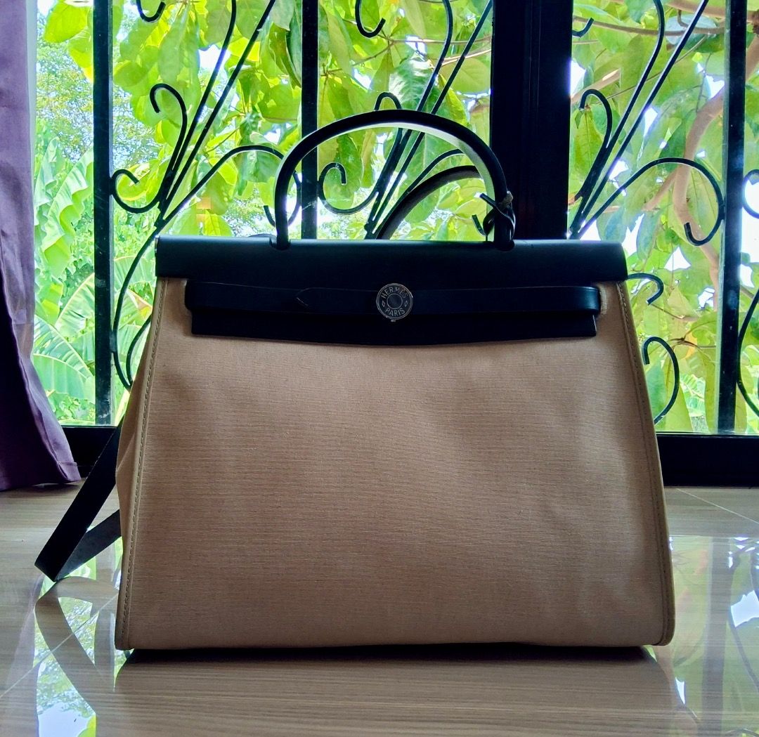 Hermes Herbag (Category: Luxury Bags & Wallets) located in Albuera. Submitted by zaraofdammam09 (Listing ID 1463199401, Image 1). Description: - Classic - Durable canvas body - Black leather trim and handles - Comes with padlock and key - Exterior zippered pocket - Interior pouch pocket - Versatile for everyday or special occasions.
