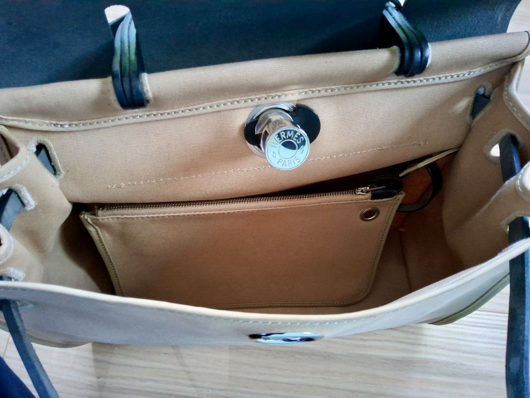 Hermes Herbag (Category: Luxury Bags & Wallets) located in Albuera. Submitted by zaraofdammam09 (Listing ID 1463199401, Image 3). Description: - Classic - Durable canvas body - Black leather trim and handles - Comes with padlock and key - Exterior zippered pocket - Interior pouch pocket - Versatile for everyday or special occasions.