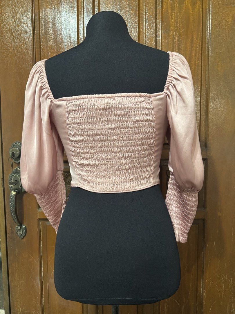 H&M Divided Pink Ruched Square Neck Crop Top (Category: Sleeveless) located in Manila. Submitted by prelovedshopmnl (Listing ID 1463134578, Image 2). Description: - Cute pink crop top from H&M Divided - Features a ruched front and smocked back - Square neckline with puff sleeves - Smocked cuffs - Versatile for pairing with jeans or skirts - Ideal for casual outings or nights out.