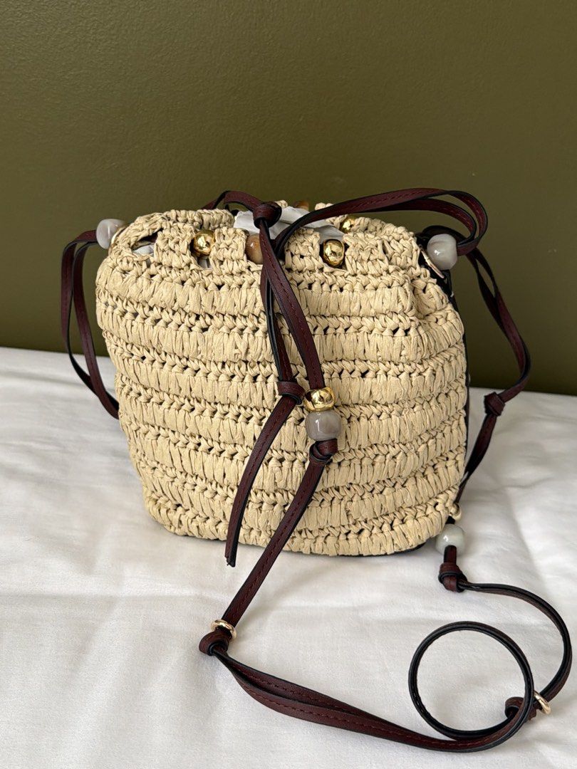 H&M Straw Bucket Bag with Leather Straps (Category: Cross-body Bags) located in Makati City. Submitted by wornbyabbie (Listing ID 1463300253, Image 1). Description: - Cute straw bucket bag - Dark brown leather straps - Drawstring closure - Decorated with small beads - Perfect for summer outings - Still in original packaging.