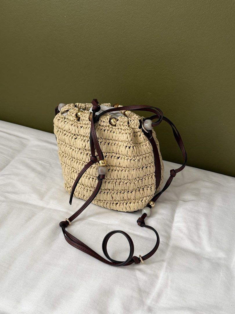 H&M Straw Bucket Bag with Leather Straps (Category: Cross-body Bags) located in Makati City. Submitted by wornbyabbie (Listing ID 1463300253, Image 2). Description: - Cute straw bucket bag - Dark brown leather straps - Drawstring closure - Decorated with small beads - Perfect for summer outings - Still in original packaging.