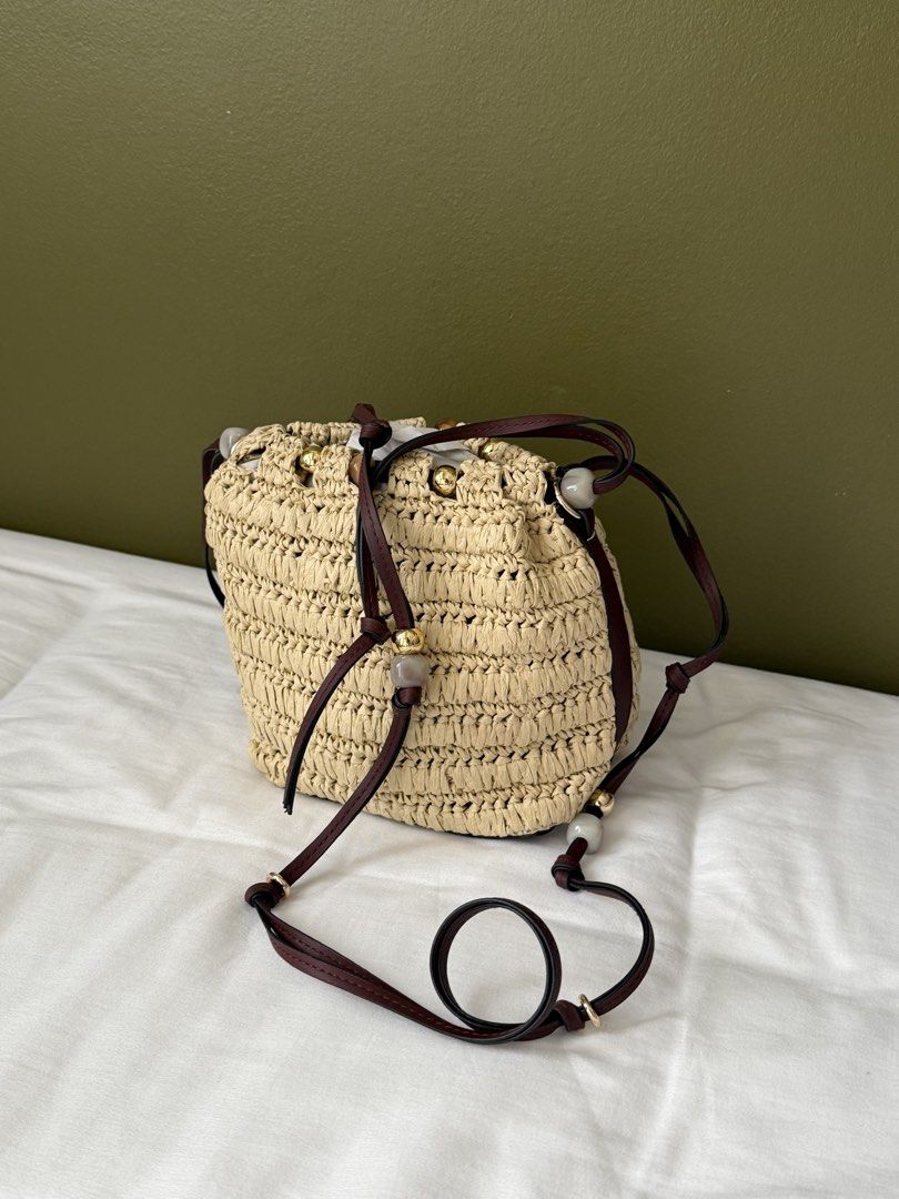 H&M Straw Bucket Bag with Leather Straps (Category: Cross-body Bags) located in Makati City. Submitted by wornbyabbie (Listing ID 1463300253, Image 3). Description: - Cute straw bucket bag - Dark brown leather straps - Drawstring closure - Decorated with small beads - Perfect for summer outings - Still in original packaging.