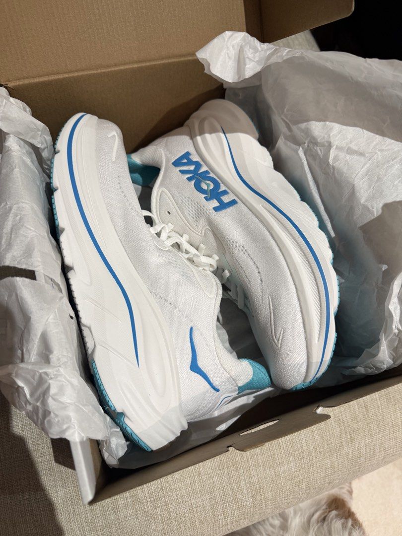 Hoka Clifton 10 Running Shoes (Category: Sneakers) located in Makati City. Submitted by ggbuckets (Listing ID 1463264809, Image 2). Description: - Brand: Hoka - Model: Clifton 10 - Color: White with blue accents - Size: 9D (US Men's) - Condition: Brand New - Includes: Original Hoka box and packaging .