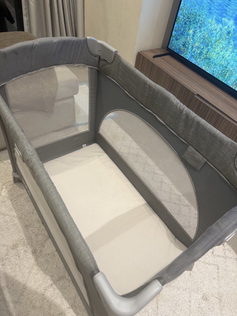 Joie Crib with Carry Bag (Category: Cots & Cribs) located in Taguig. Submitted by laramagbalana (Listing ID 1462664548, Image 2). Description: - Joie travel cot in stylish grey. - Comes with a convenient carry bag for easy transport. - Features mesh sides for optimal ventilation. - Folds down compactly for storage and travel. - Equipped with wheels on one side for effortless moving. - Ideal for trips or as a handy spare cot. - Newly deep cleaned 